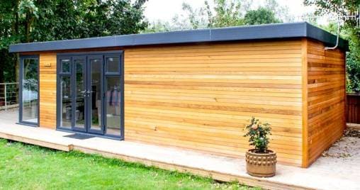 Una dependance prefabbricata in legno nel giardino di una villa.