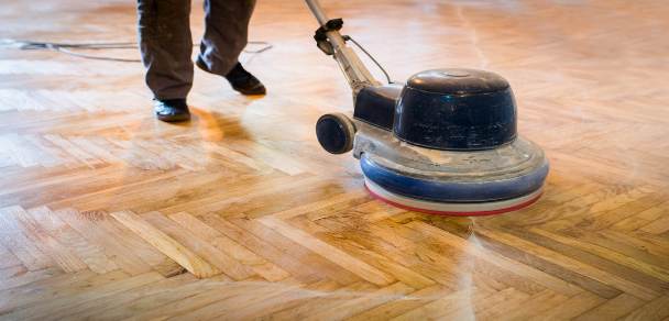 La levigatura di un parquet con attrezzatura professionale.