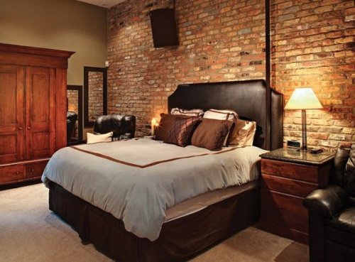 Una camera da letto con una parete in mattoncini.