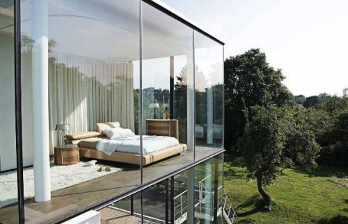 Una casa con delle pareti in vetro esterne.