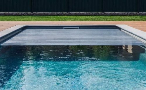 Una piscina con copertura a serranda.