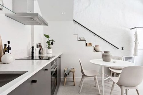 Sala da pranzo con cucina a vista di una casa ristrutturata nel quartiere Musocco a Milano.