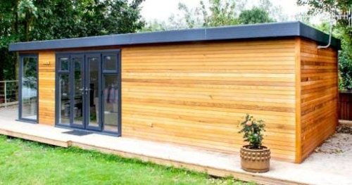 Una dependance prefabbricata in legno nel giardino di una villa.