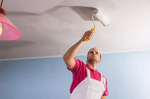 Un imbianchino mentre tinteggia un appartamento a Milano.