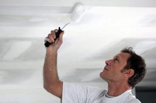 Un imbianchino che tinteggia un soffitto a Firenze.