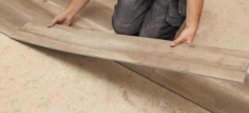 La posa di un pavimento vinilico.