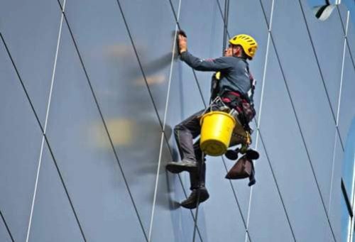 La pulizia della facciata in vetro di un edificio direzionale.
