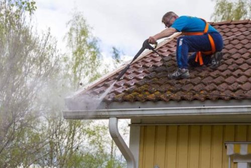 La pulizia di una grondaia con una idropulitrice.