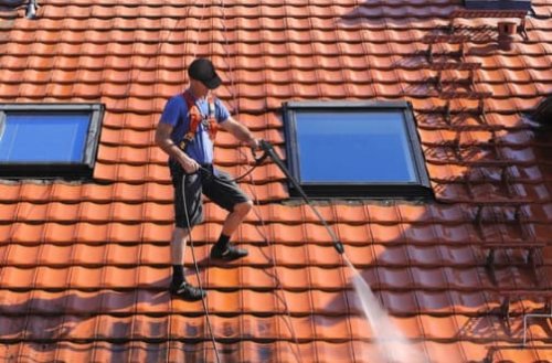 La pulizia professionale di un tetto con idropulitrice.