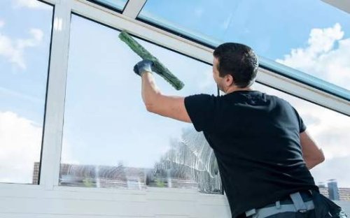 Pulizia di una vetrata da parte di un professionista.