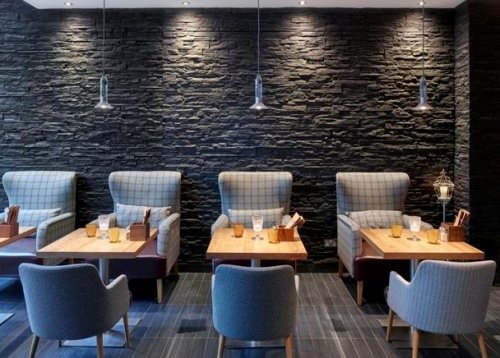 Il render di un ristorante con rivestimenti interni in pietra.