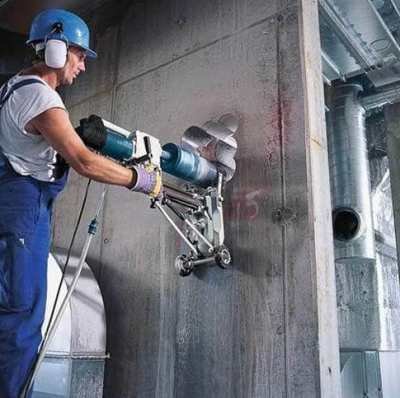 Un intervento di carotaggio di una parete in cemento armato per creare delle prese di servizio.