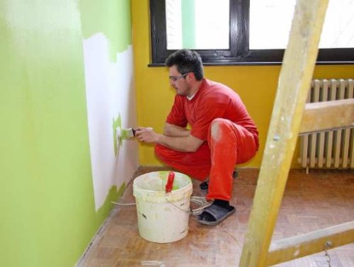Un imbianchino durante la tinteggiatura di una casa a Modena.